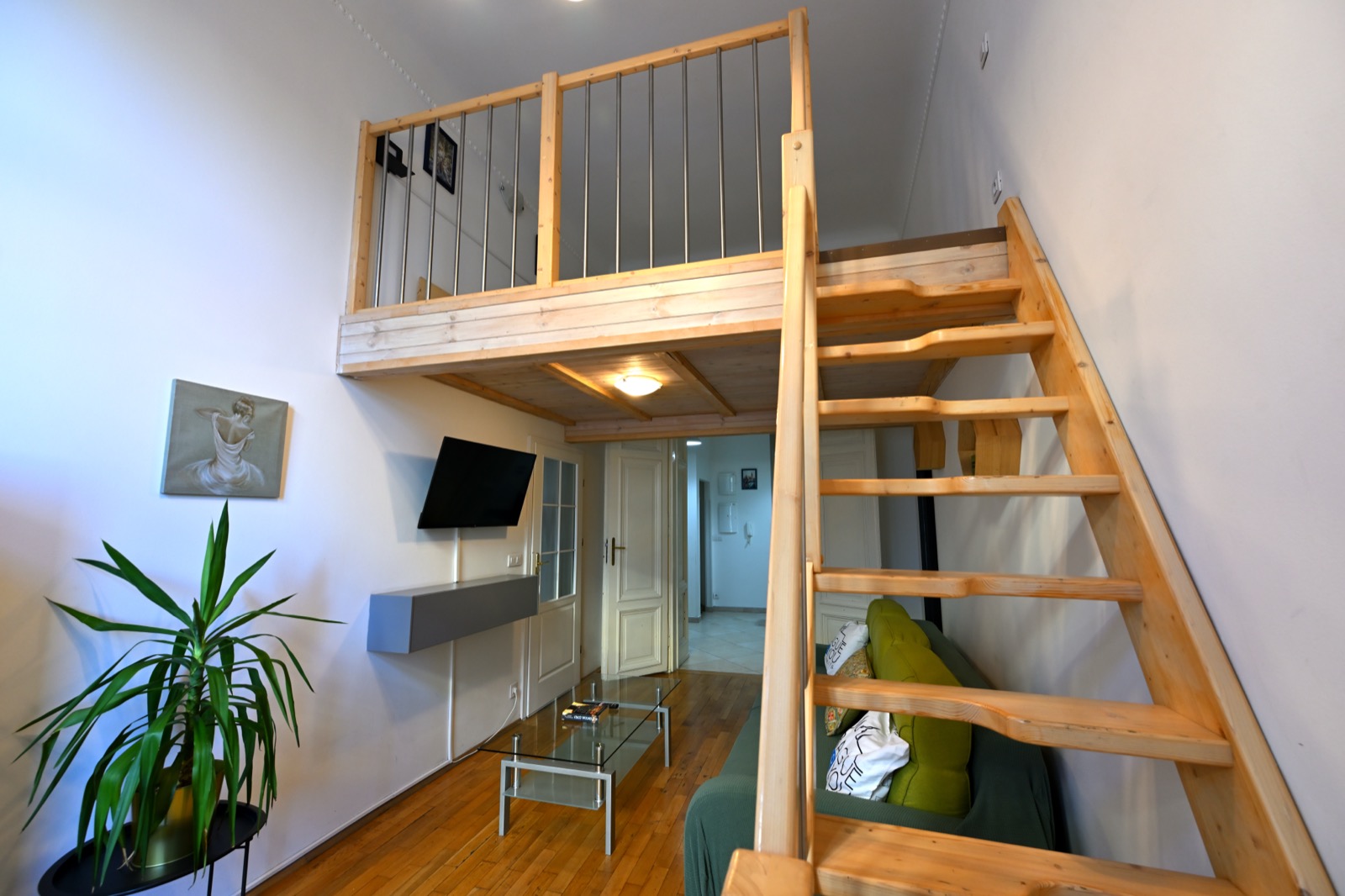 Apartmán H01 — mezonet s dřevěným patrem a zelenou pohovkou