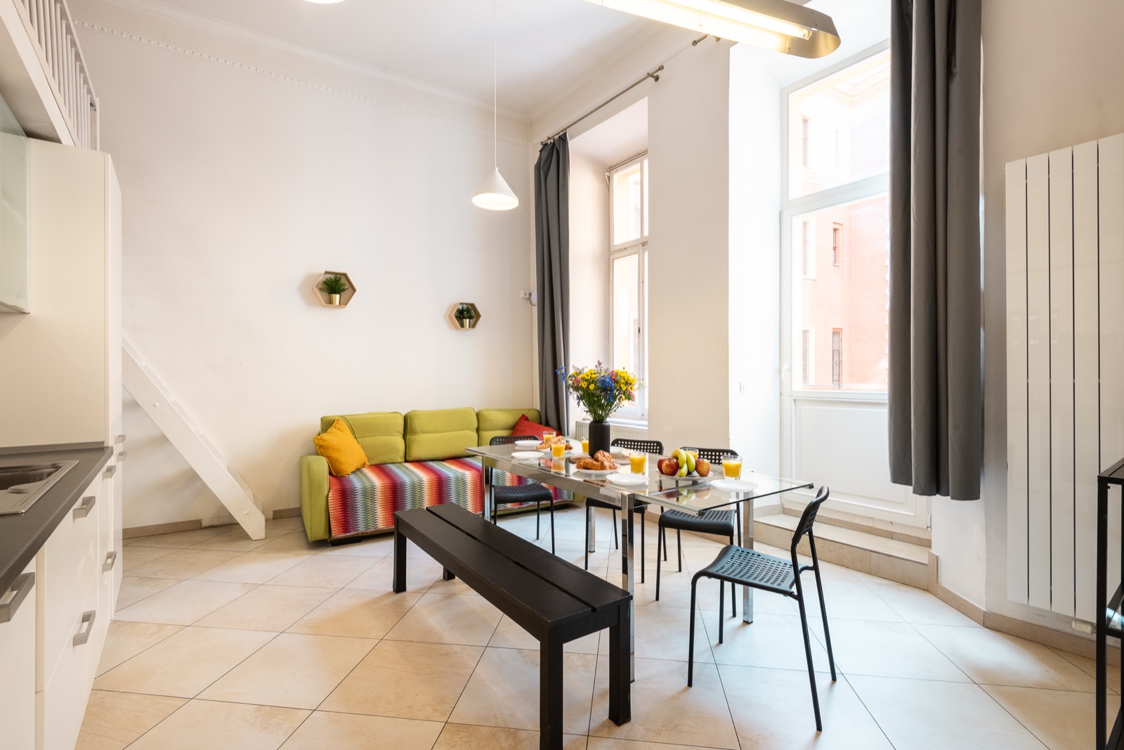 Apartmán H02 — obývací část s pruhovanou pohovkou a velkým oknem